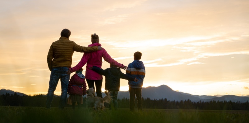 A family standing outdoors at sunset, staying active and maintaining healthy vision.