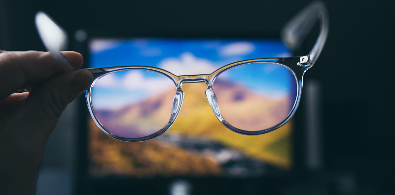A pair of blue light glasses facing towards a screen
